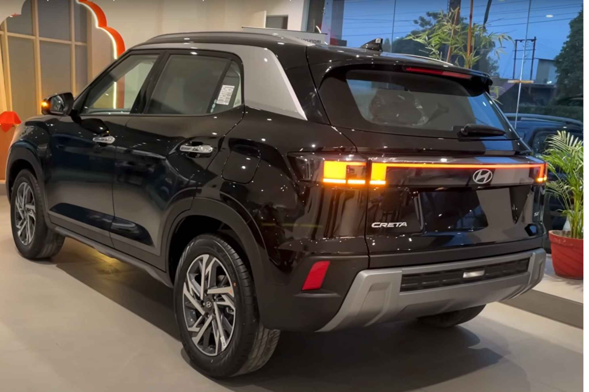 Rear view of the Hyundai Creta 2025 in black, showcasing updated LED tail lamps and bold SUV styling in a showroom setting